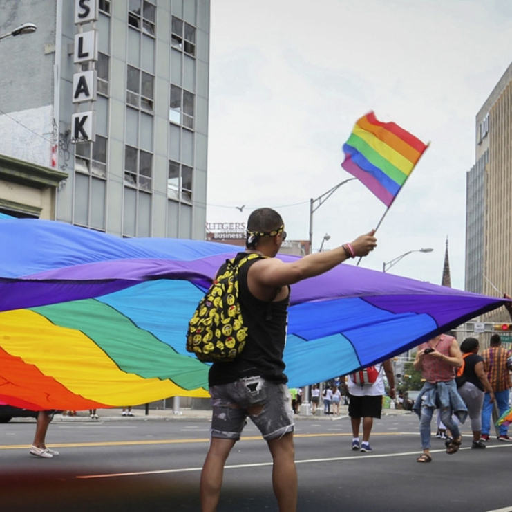 carrying a giant rainbow flag in a parade